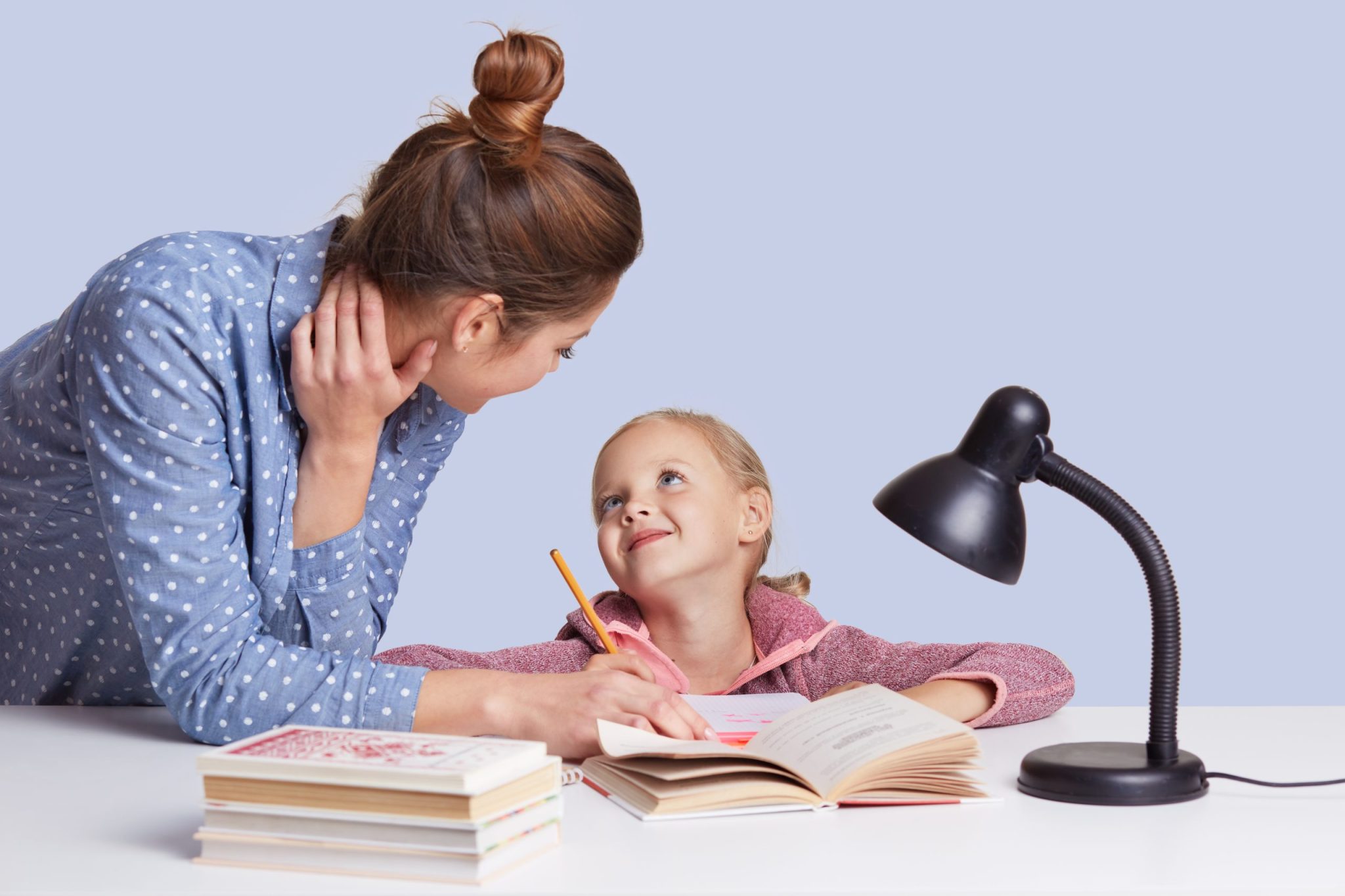 mother-and-daughter-sitting-at-table-surrounded-by-books-looking-at-each-other-with-love-doing-homework-together-mummy-helps-little-girl-to-do-sums-ch-Feb-27-2024-08-42-20-1541-PM